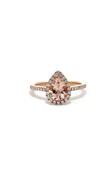 Rose gold engagement ring with a pear-shaped morganite center stone surrounded by a halo of diamonds. 