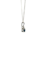 Side view silver necklace with a teardrop-shaped blue sapphire pendant