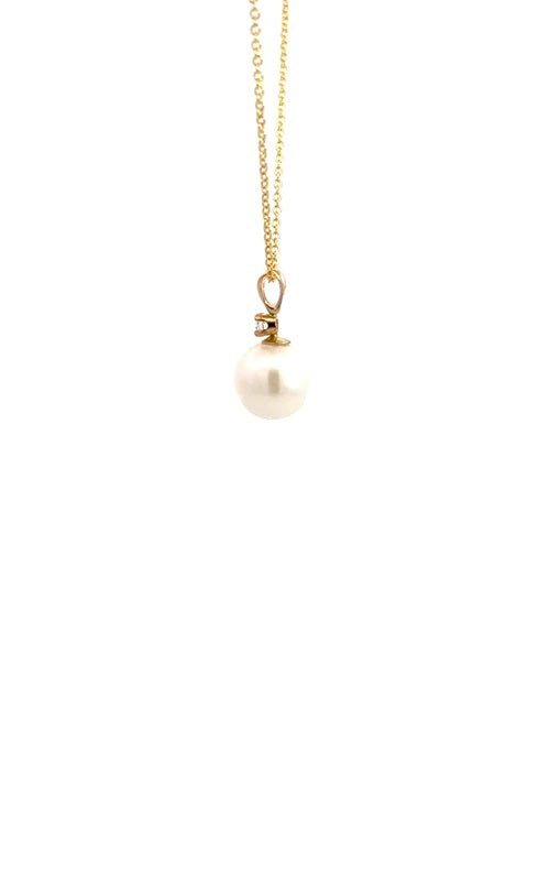 Side view of gold necklace with white pearl pendant with diamond accent