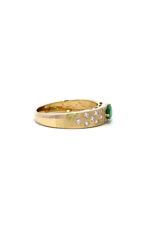 Gold ring band with a pear-shaped emerald surrounded by smaller diamonds.