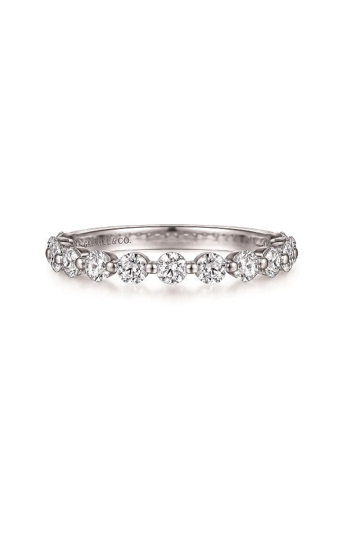 Thin silver wedding band featuring a shared prong setting with round diamonds.