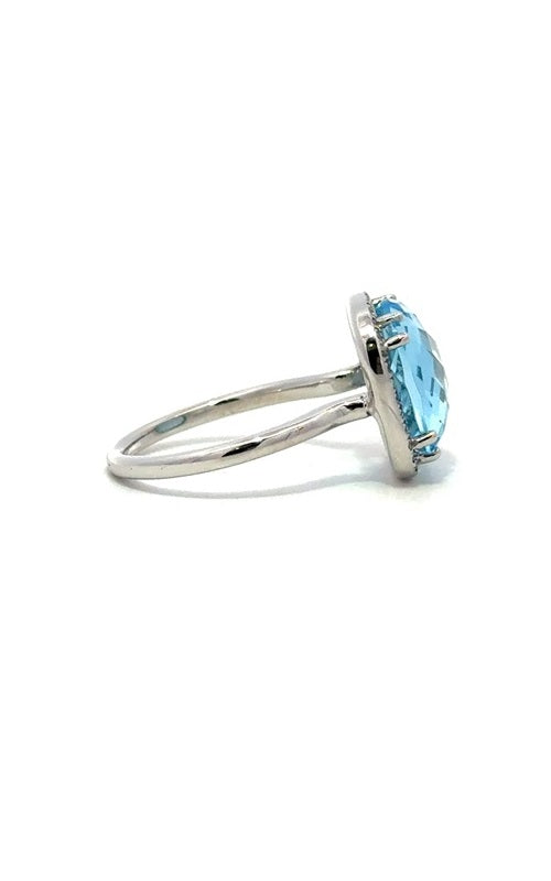 Side view of a silver ring with a large, oval-shaped blue topaz gemstone